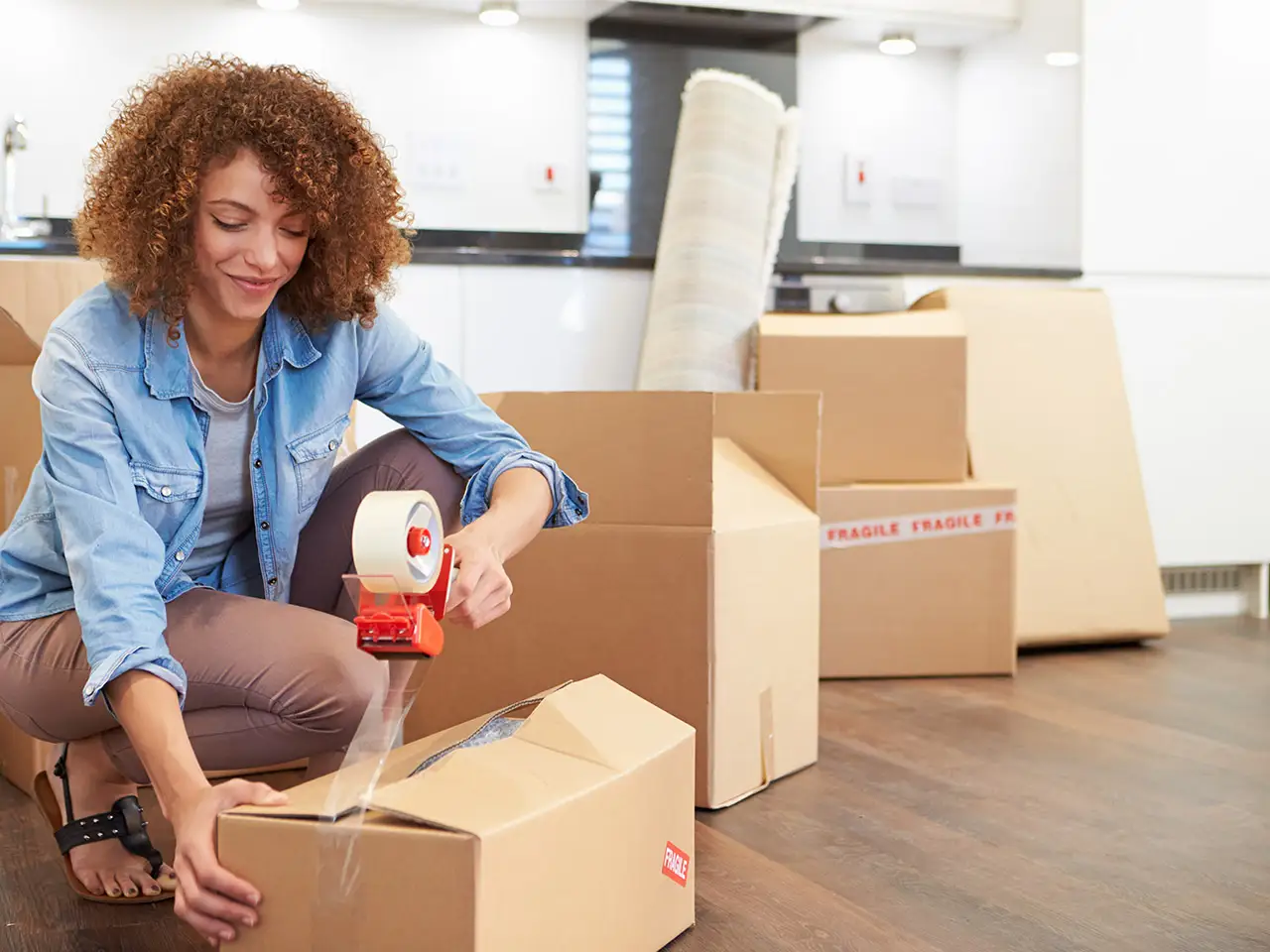 Eine junge Frau beim Verpacken von Umzugskartons